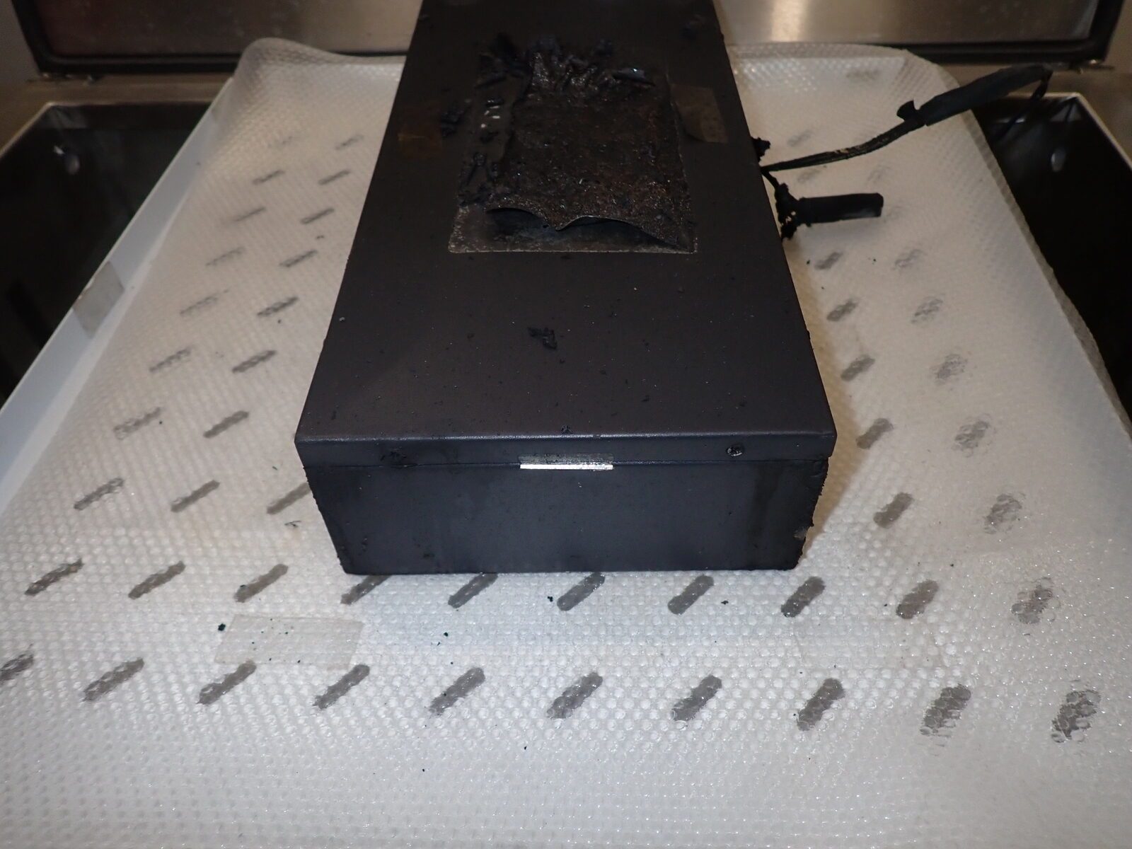Bateria litowa wyjęta z Charge Cabinet po thermal runaway, z wypalonym fragmentem obudowy